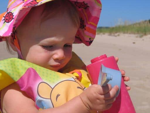 Toddler girl playing on the beach.