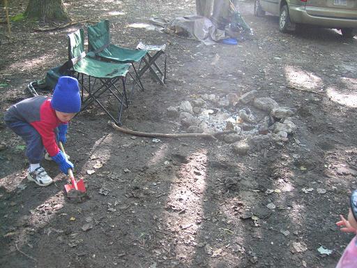 Young boy digging in the dirt.