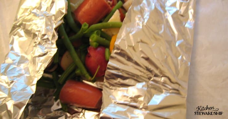 Package of veggies and hot dogs in foil, campingfood