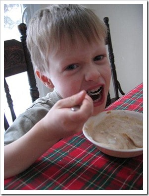 A young boy eating yogurt with applesauce