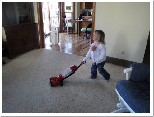 Little girl vacuuming with baby