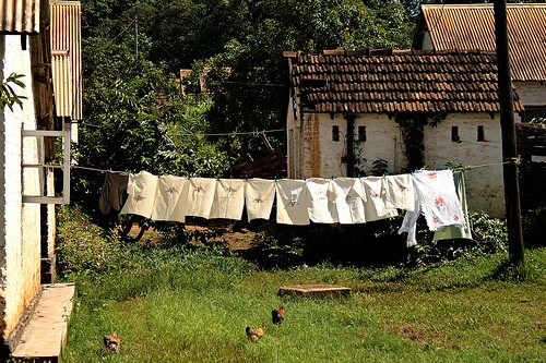 Laundry hanging on a clothesline in front of a rustic farm building
