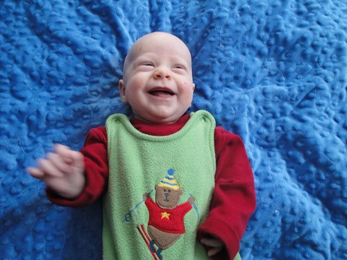 Baby smiling after a newborn cloth diaper change.
