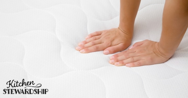 hands pressing on a mattress