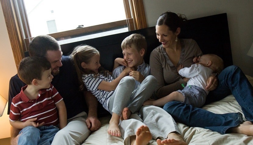Family being silly on a bed