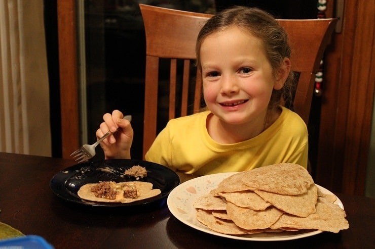 7 year old eating tacos on homemade tortillas she made.