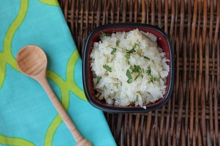 Bowl of cauliflower rice on a wicker table with a colorful placemat