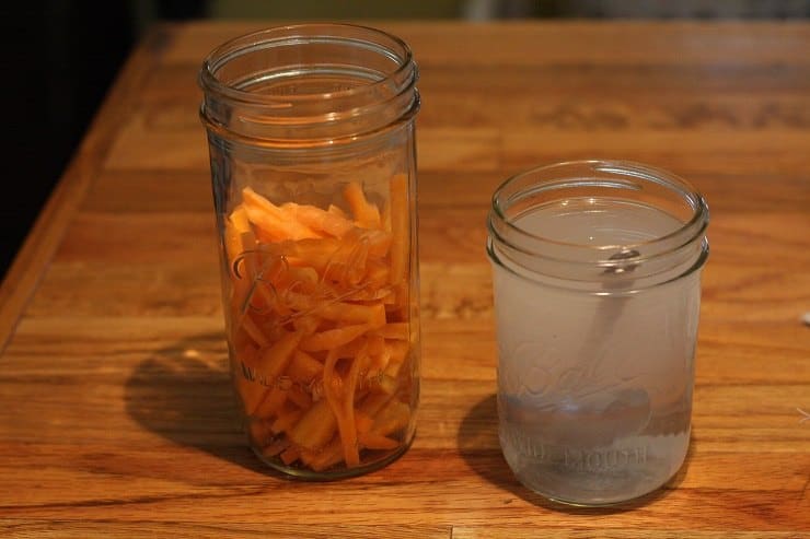 Fermented carrots with a jar of salt water brine
