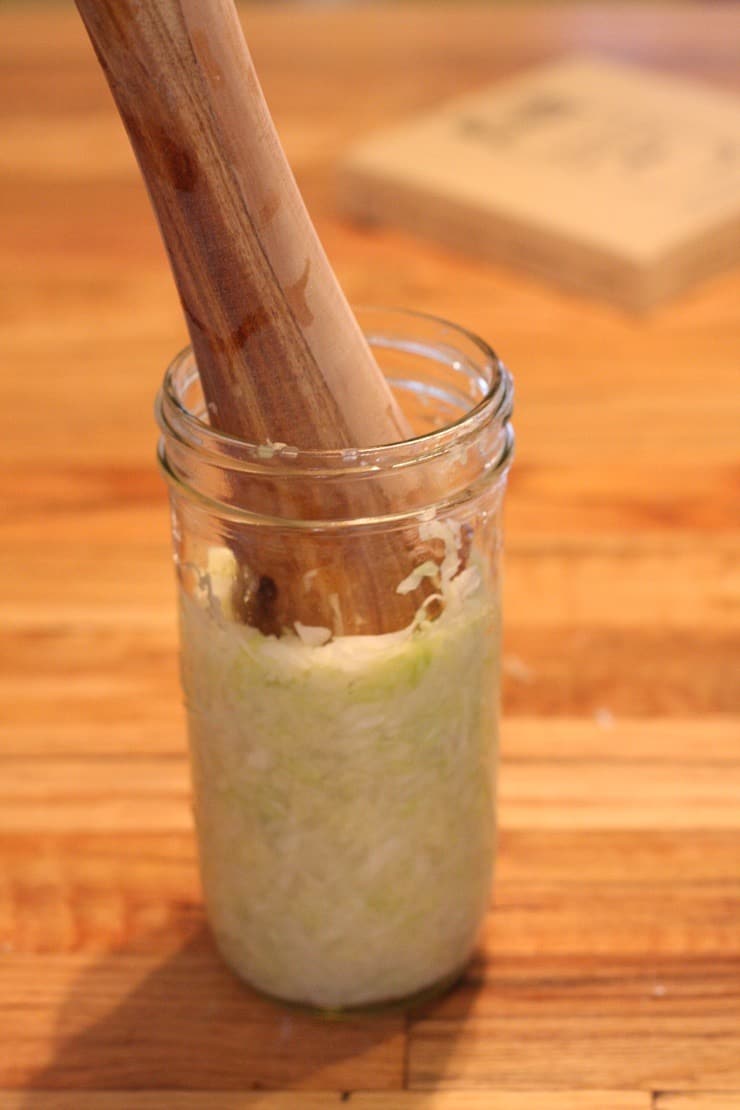 Packing cabbage into the jar with the Masontops Pickle Packer