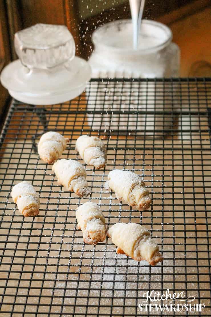 sprinkling powdered sugar on kifli Christmas cookies