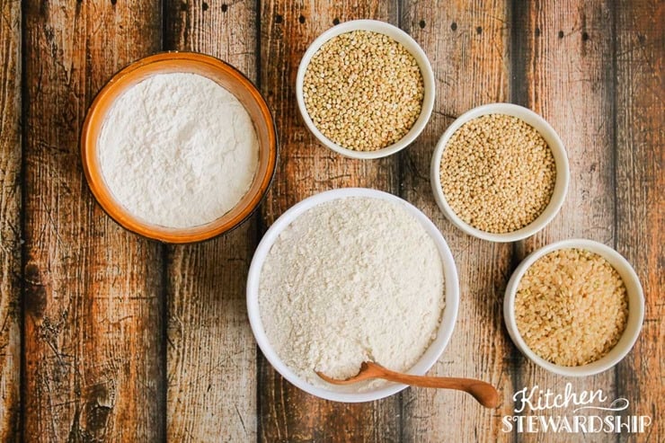 freshly ground gluten-free flour blend in bowls next to their grains 