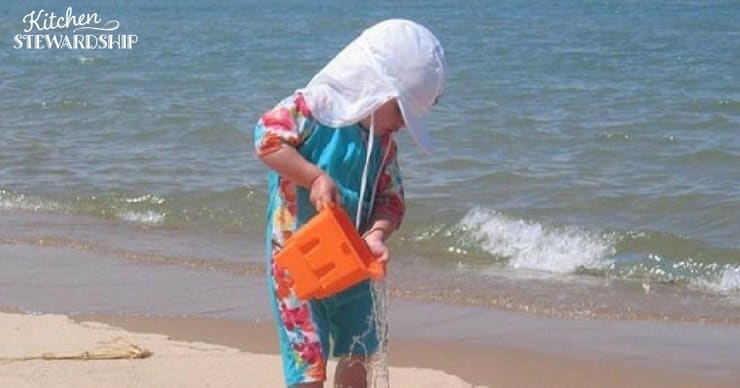 Child on a beach in sun-protective clothing