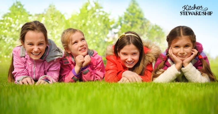 Young girls laying in the lawn.