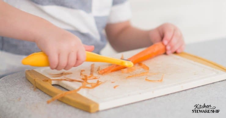Young boy peeling carrots. 