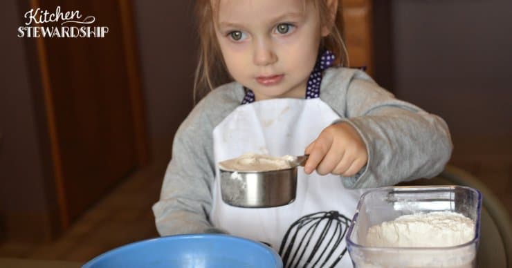 girl scooping flour
