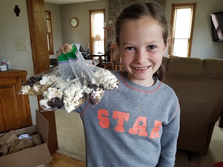 Girl holding bags of trail mix