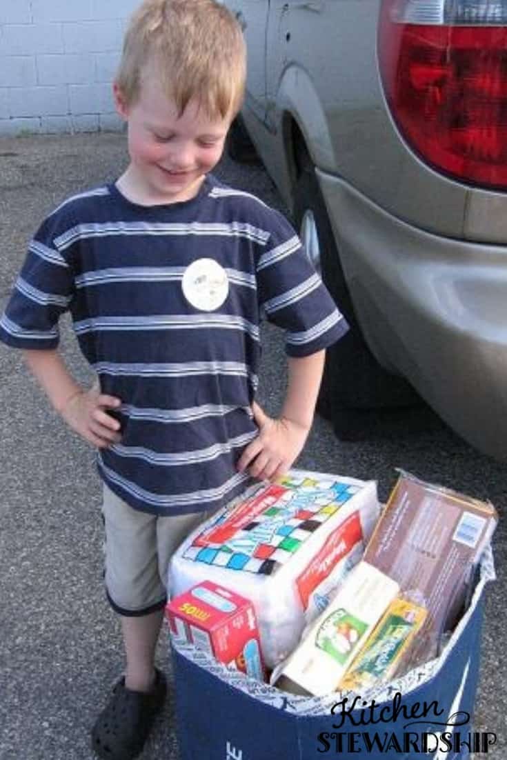 Boy standing by a bag of stuff to donate, non food idea for kid birthday party