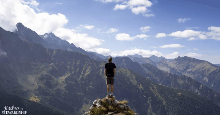 man alone looking at mountains
