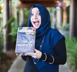 Dr. Madiha Saeed holding her book, The Holistic RX