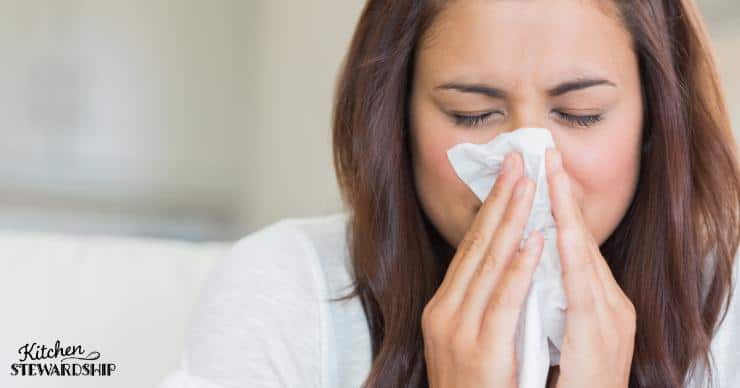 Woman blowing her nose with a disposable tissue