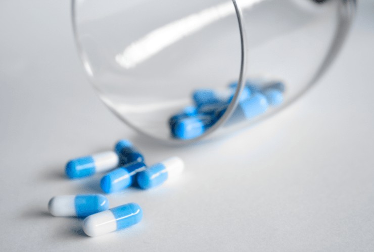 blue and white medicine capsules on a white counter