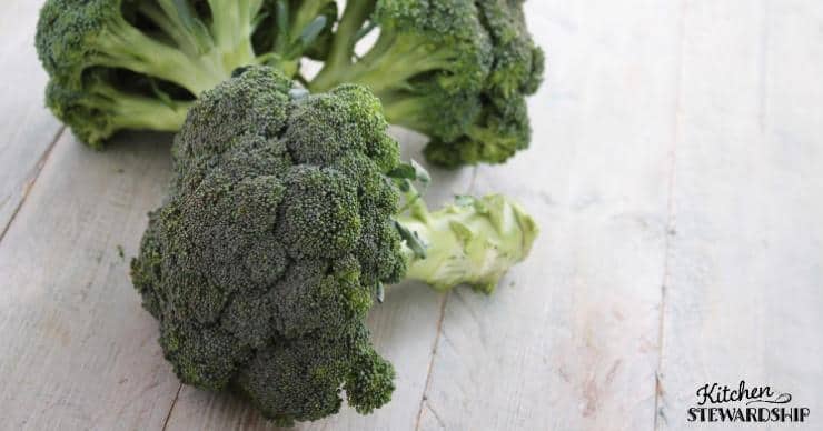 heads of broccoli on a white plank table