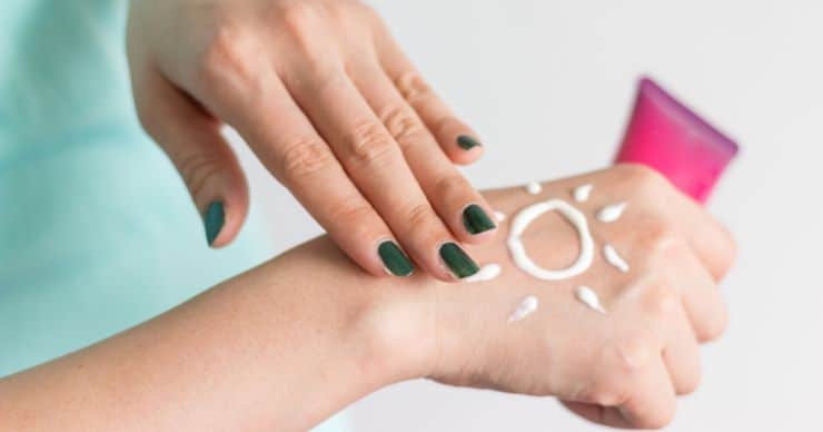 woman putting sunscreen on