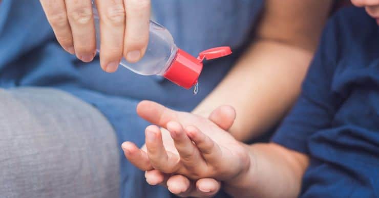 kid using hand sanitizer