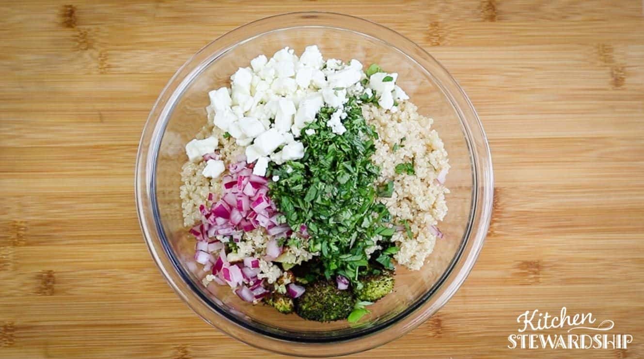 roasted veggie and herb salad being mixed up