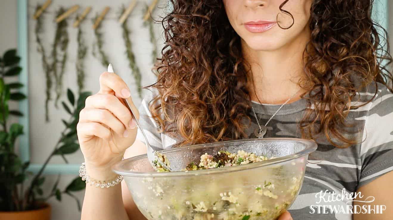 woman holding a bowl of roasted veggie salad