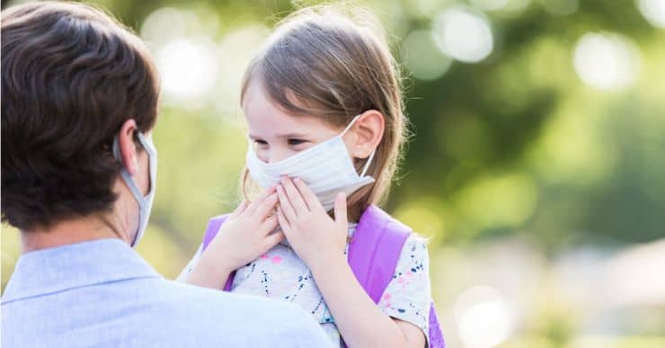 child touching face mask