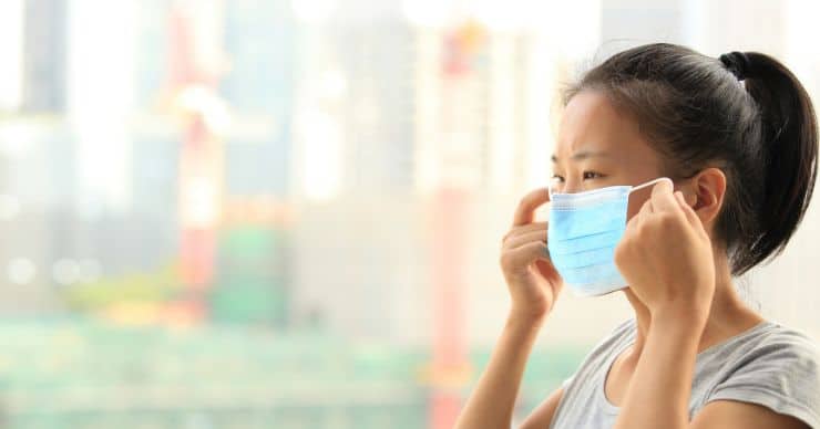 woman putting on face mask