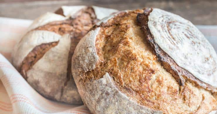 2 loaves of artisan bread on a kitchen towel