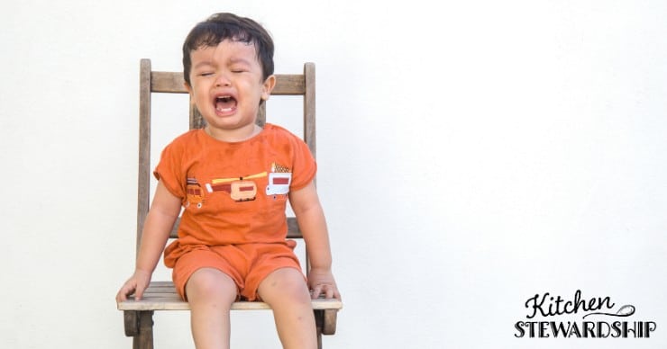 Upset toddler sitting in a chair