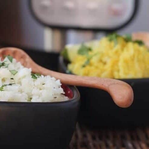 2 bowls of cauliflower rice, each with different seasonings, in front of an Instant Pot
