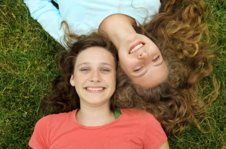 Two girls laying on the grass