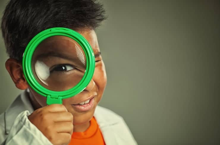 child looking through magnifying glass