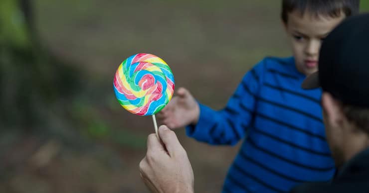 stranger giving a child a lollipop