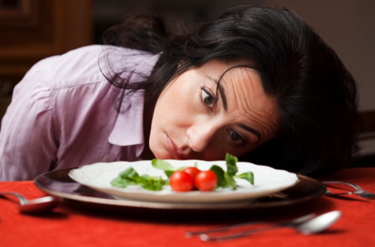 woman looking at a tiny salad