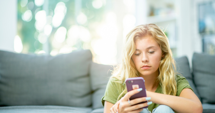 teen looking at cell phone