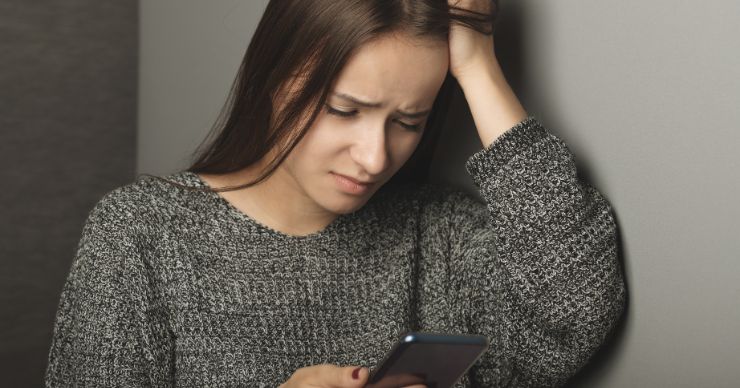 upset teen with phone